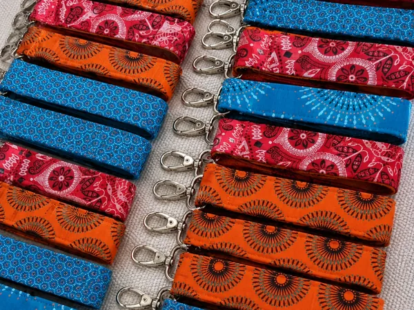 Handmade shweshwe wristlet keyrings in orange, red and blue prints with metal clips