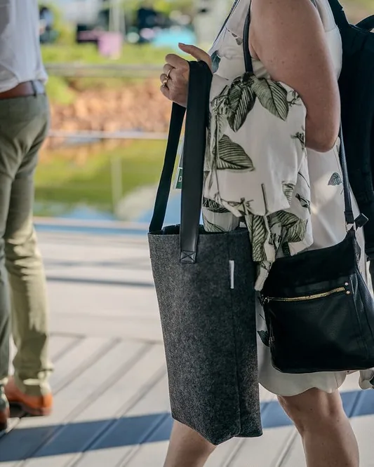 Structured grey RPET felt conference bag carried by a professional