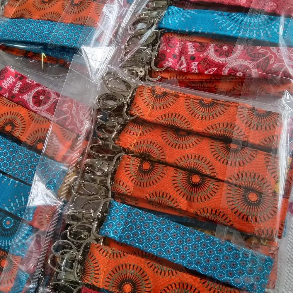 Pile of handmade orange shweshwe fabric keyrings ready for packing